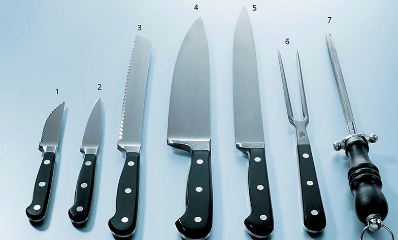 Rüstmesser mit Wellenschliff (1) und mit glatter Klinge (2), Brotmesser (3), Koch- oder Gemüsemesser (4), Fleisch- oder Tranchiermesser (5), Tranchiergabel (6), Wetzstahl (7).
