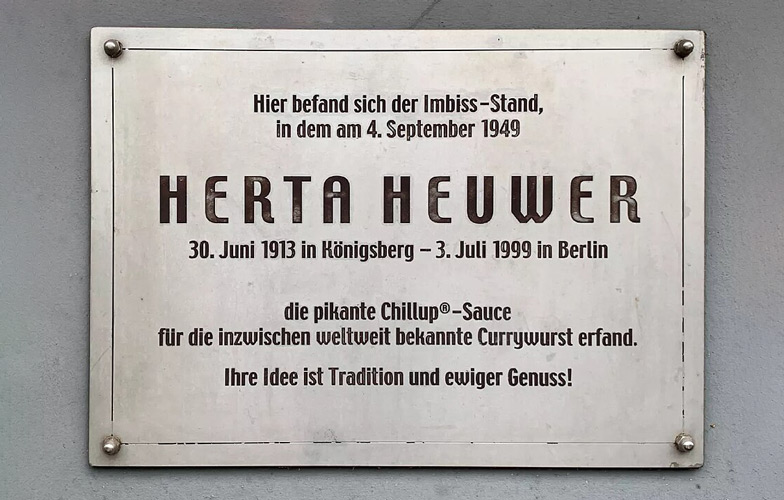 Cette plaque commémorative au coin d’une maison de Berlin-Charlottenburg rappelle l’emplacement de la légendaire barraque à saucisses de Herta Heuwer. <br>Photo: Richard Mischau, Britta Mischau, CC0, via Wikimedia Commons